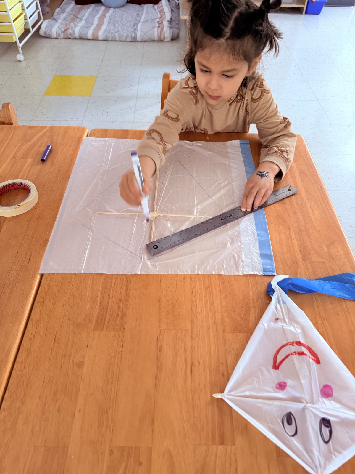 Child building a kite during aerodynamics week